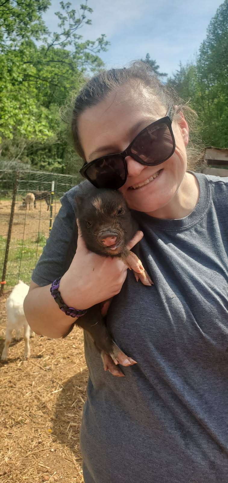 Tabatha Loyd on the farm holding a piglet